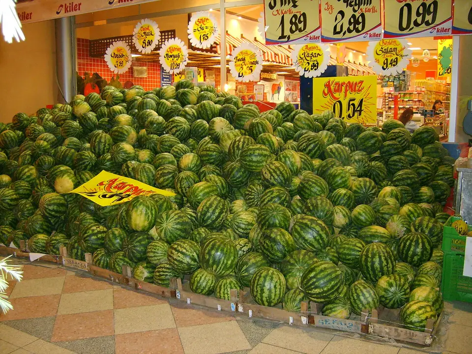Satış yerinde yığılmış karpuzlar ve fiyat levhaları