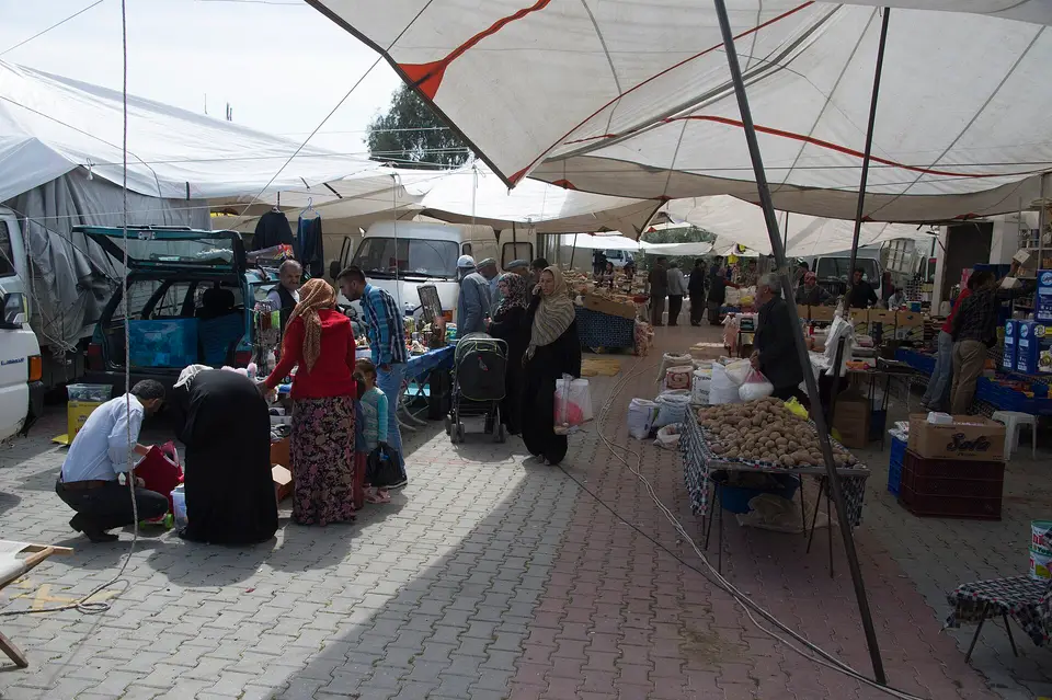 Kaş'ın Kınık beldesinde pazar gününde beyaz tente çatının altında uzanan tezgâh koridoru