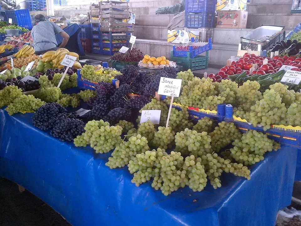 Pazar tezgâhında fiyat kartlı yeşil ve siyah üzümler
