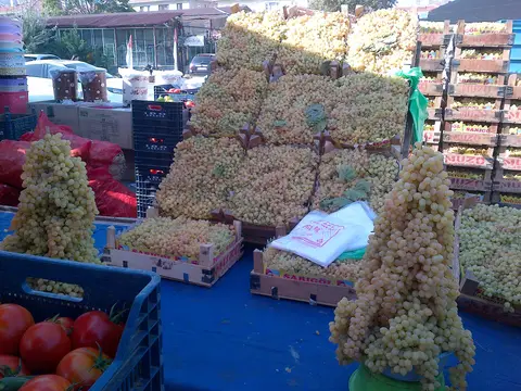 Pazarda kasalar hâlinde üst üste dizilmiş üzümler